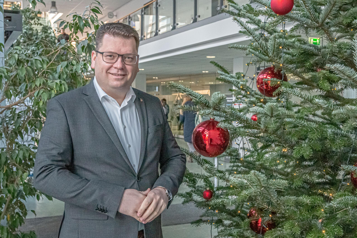 Landrat Christian Tylsch steht neben dem Weihnachtsbaum