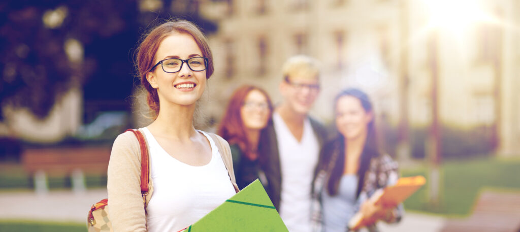 glückliche Schüler mit Schulmappen in der Hand