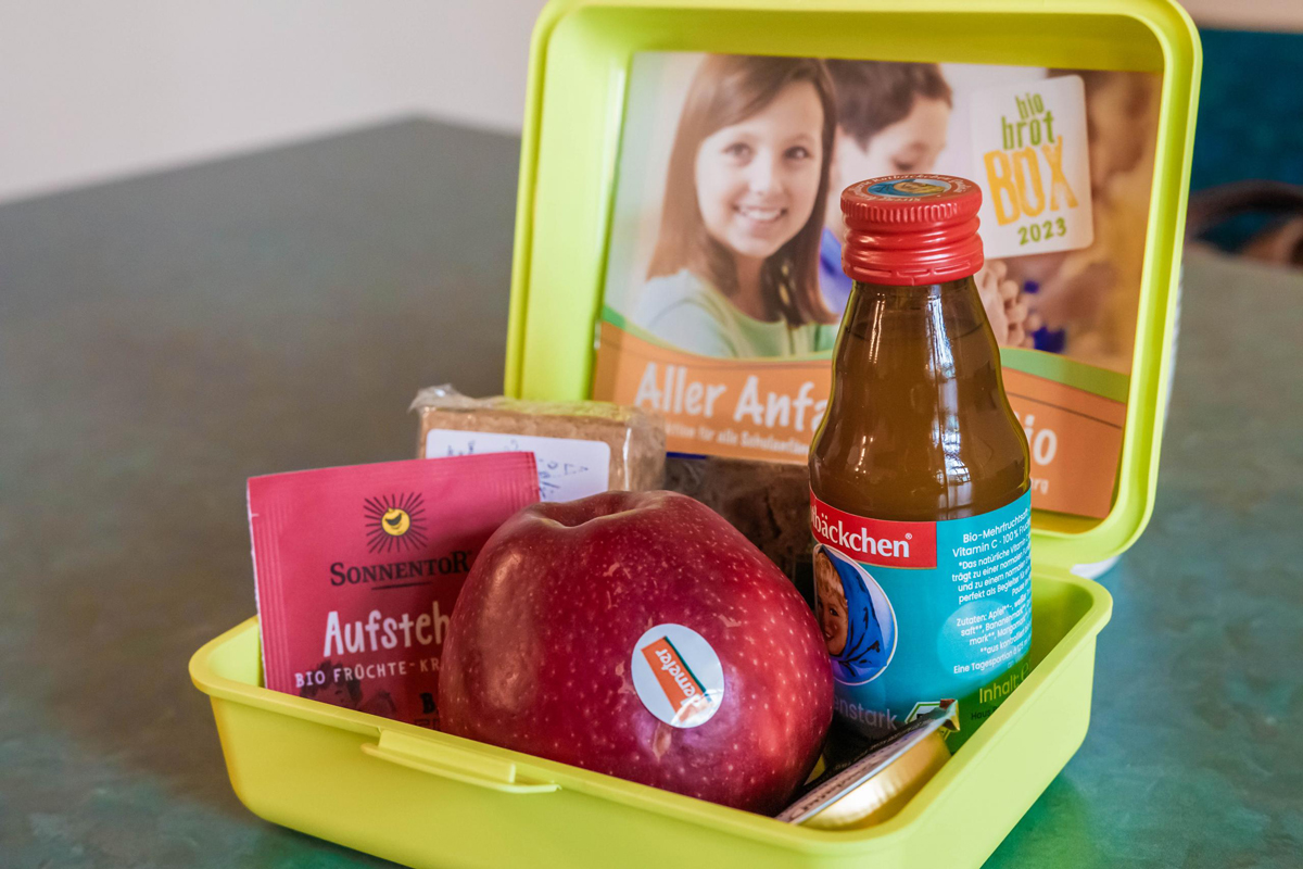 Darstellung des Inhaltes der Bio-Brotbox des Landkreises Wittenberg - Rotbäckchensaft, Tee, Apfel, Bio-Aufstrich, Dinkelkekse