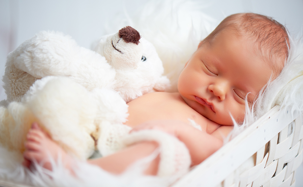 neugeborenes Baby schläft mit Spielzeug-Teddybär