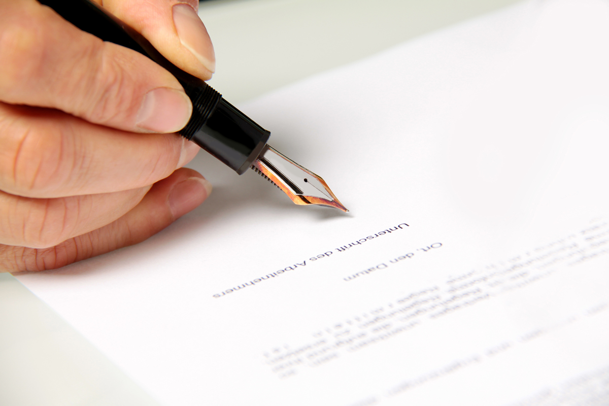 Ein Dokument wird mit einem Füller unterschrieben