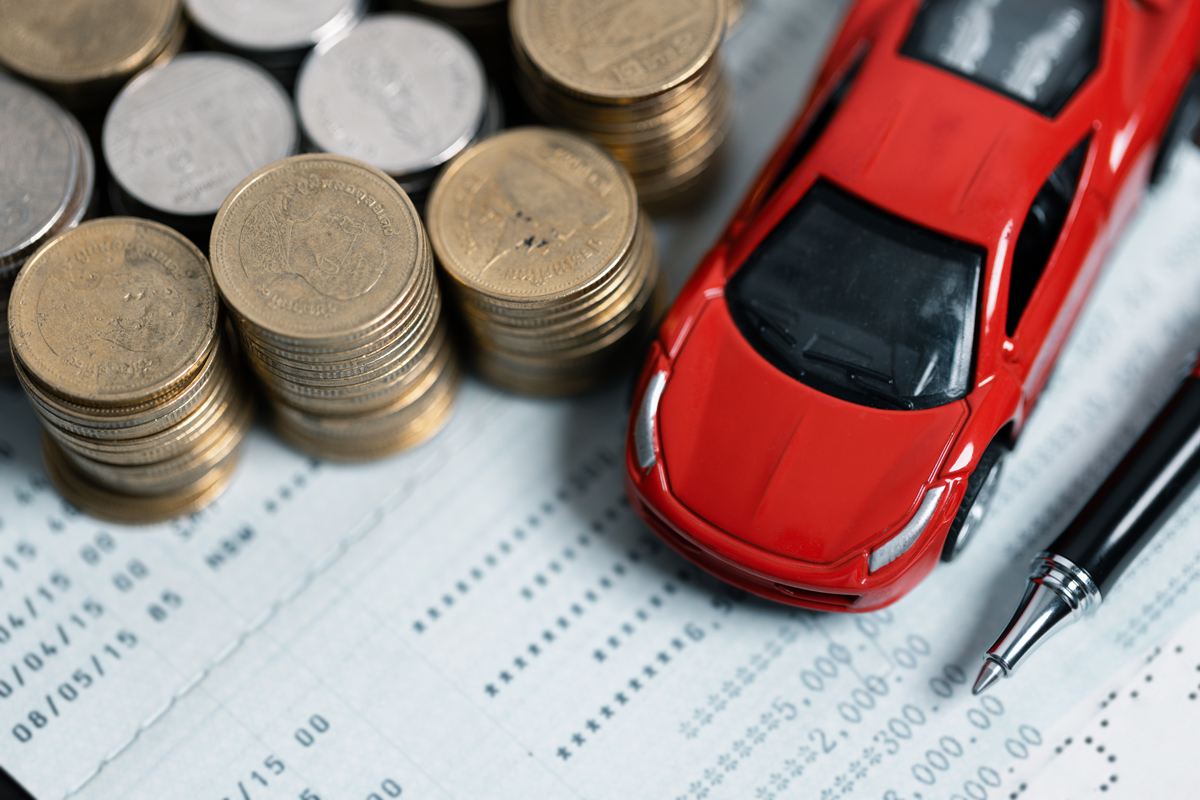 Miniaturautomodell und Finanzbericht mit Münzen.