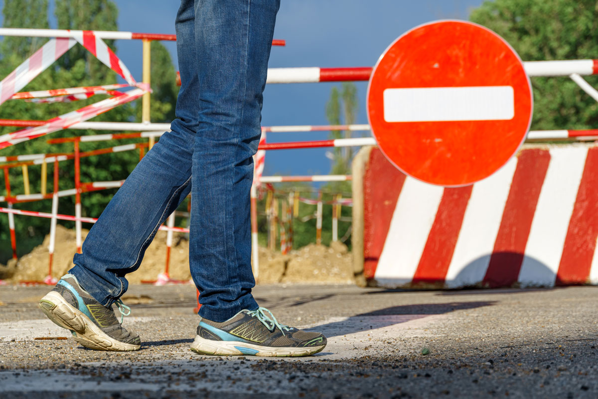 an einer Baustelle geht eine Person vorbei