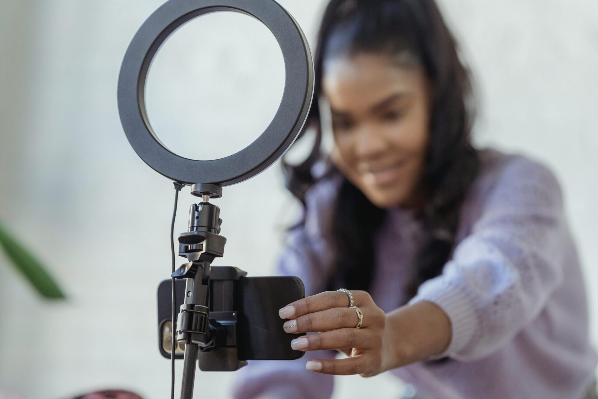 Eine Frau filmt sich mit einem Smartphone und einem Ringlicht selbst