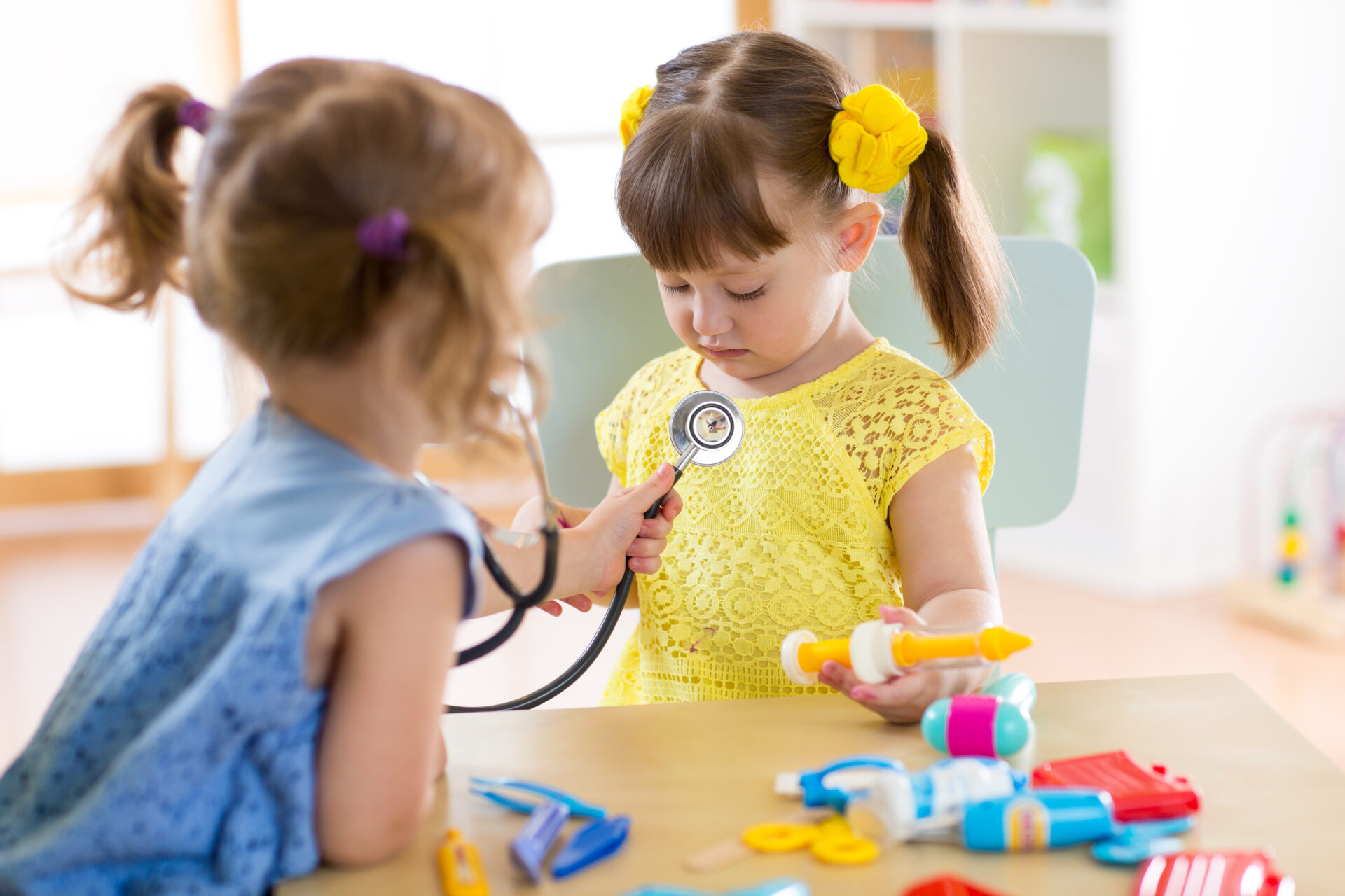 Zwei Kinder spielen Arzt mit Stethoskop.