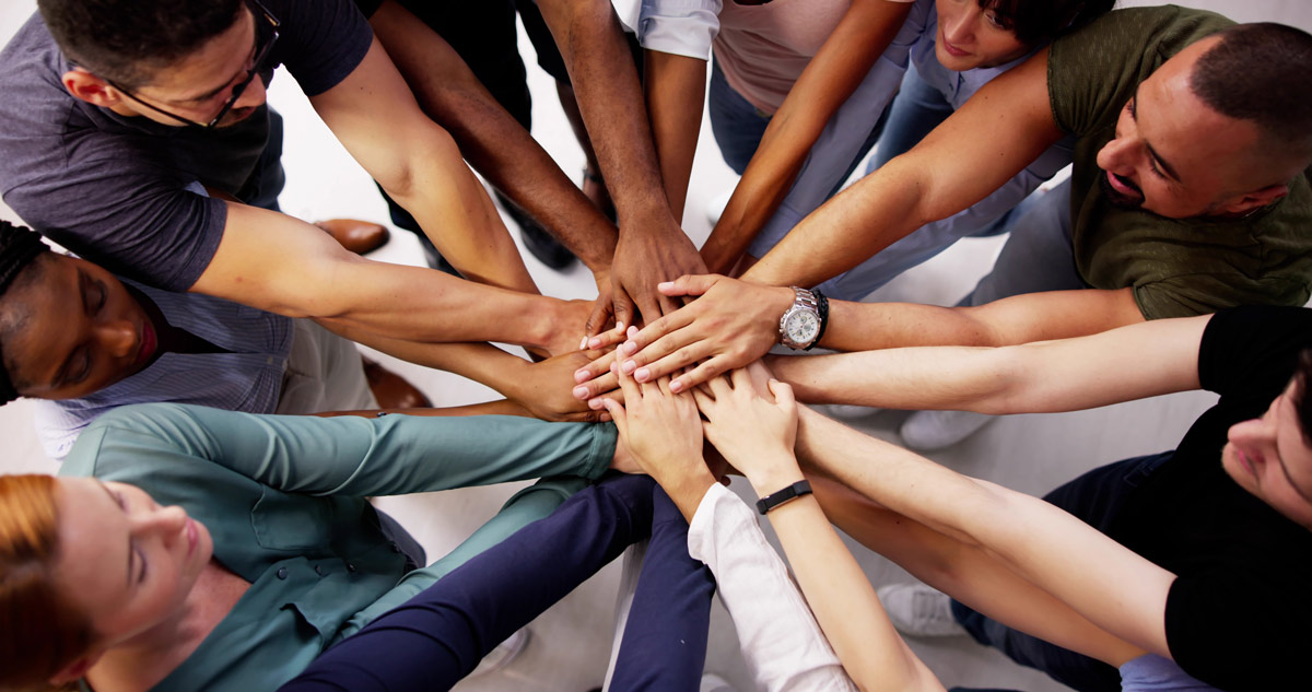 Teambildung - Team halten ihre Hände in der Mitte zusammen