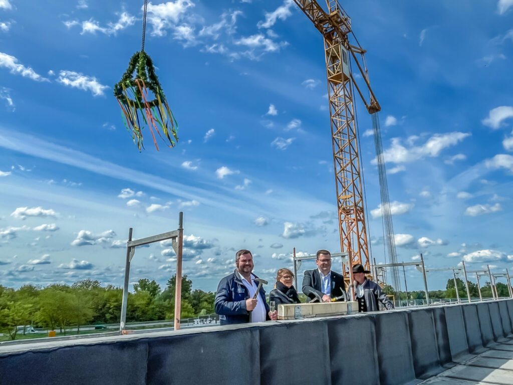 Der symbolische letzte Nagelschlag von Landrat Christian Tylsch (re.) mit dem Kreistagsvorsitzenden Enrico Schilling (Mitte) und Archivleiterin Ines Kluge beim Richtfest des Kreisarchivs der Kreisverwaltung Wittenberg.