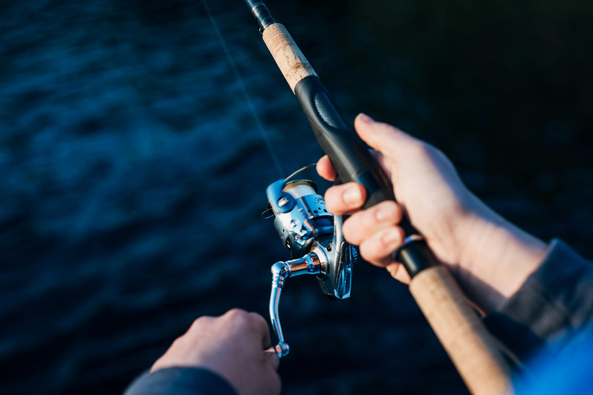 Ein Angler angelt mit seiner Angelrute an einem Gewässer.
