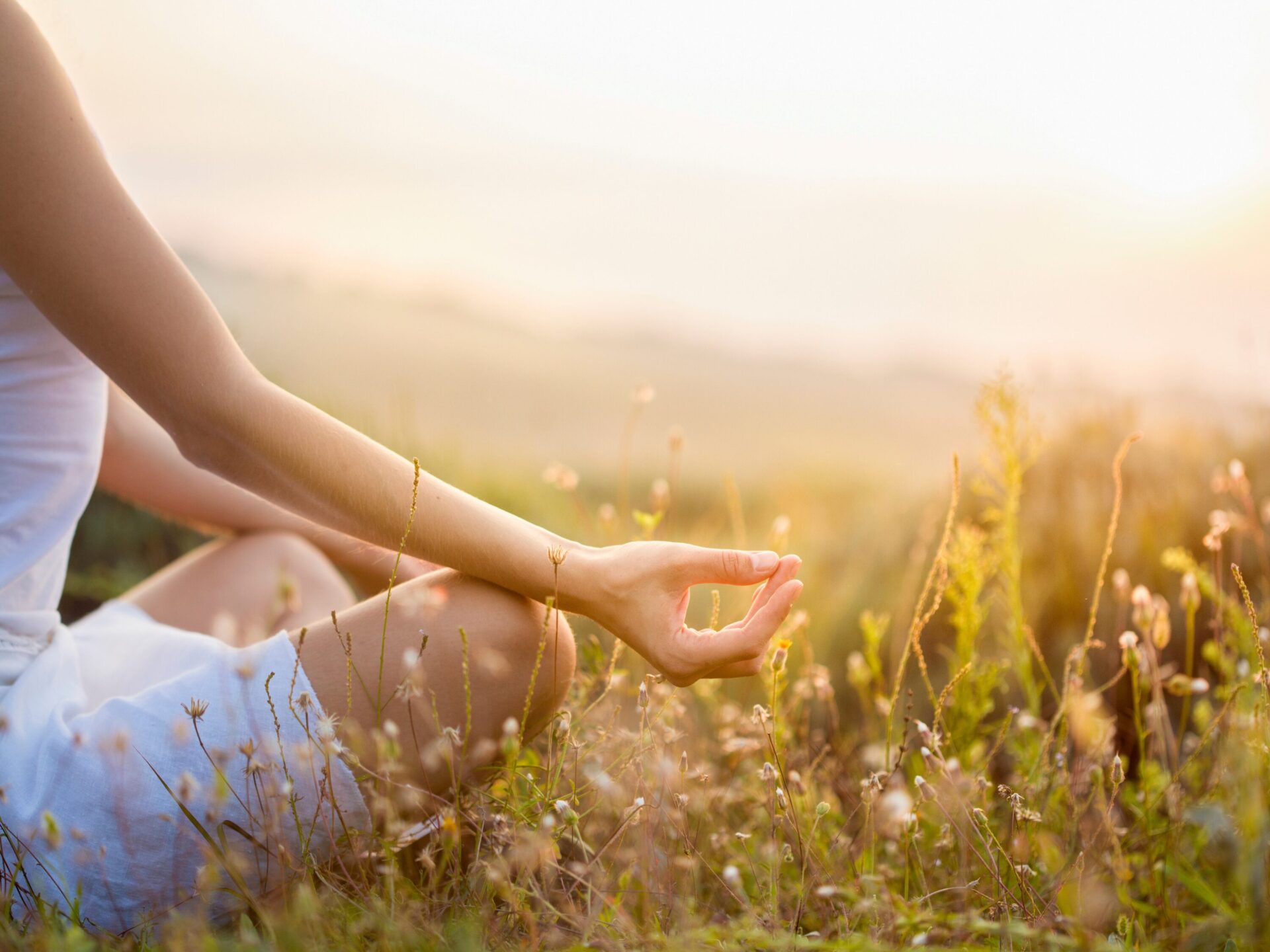 Frau macht Yoga-Übung auf der Wiese