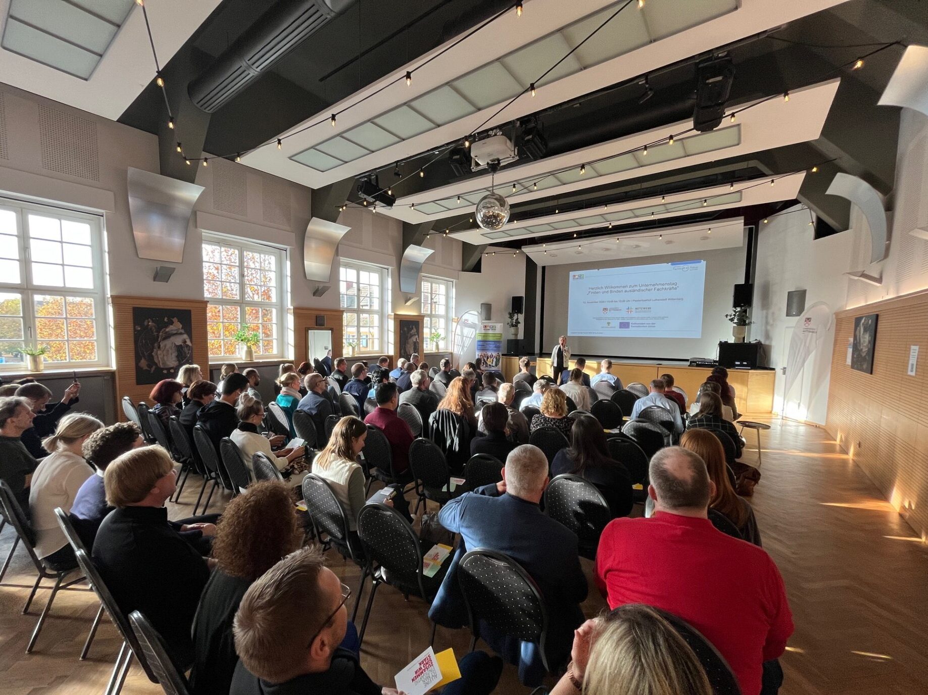 Saal gefüllt mit Menschen auf Stühlen bei Veranstaltung im Piesteritzer Hof