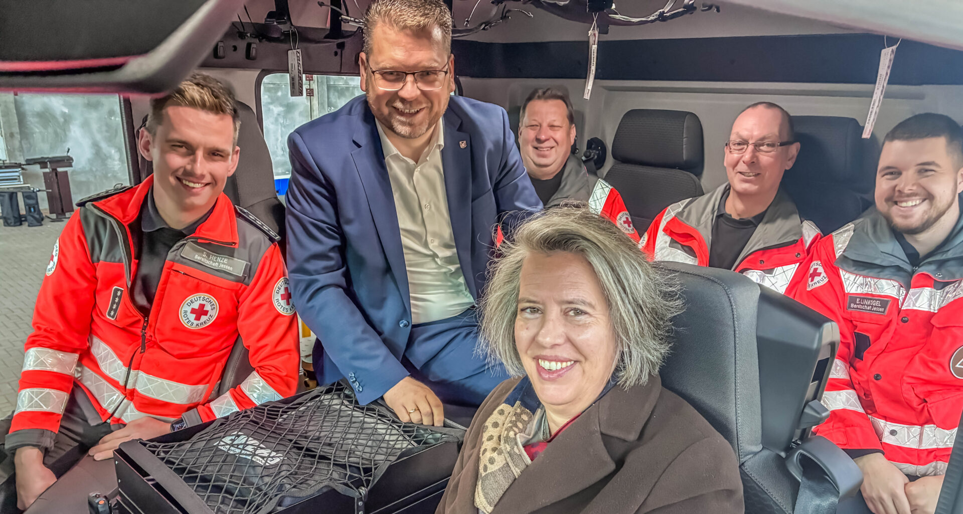 Landrat Christian Tylsch, Tamara Zieschang und Helfer des DRK Jessen machen gemeinsam Probesitzen im neuen Gerätewagen Betreuung.