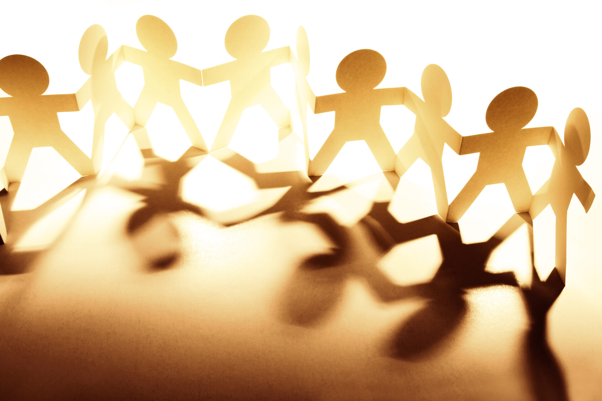 Papierschnitt mit mehreren Männchen, die sich an den Händen halten