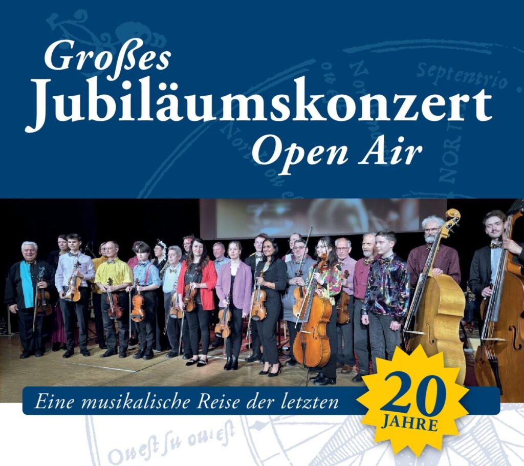 eine große Gruppe Menschen steht mit Instrumenten auf einer Bühne
