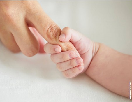 Babyhand fasst den Finger einer erwachsenen Hand