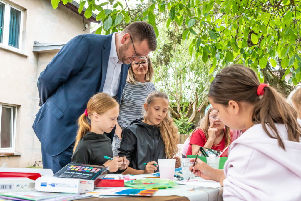 Landrat Christian Tylsch besuchte am 7. Juli 2026 die 5. regionale Ferienwerkstatt im Freizeittreff „Wiesengrund“ in Jessen. Unter dem Motto „Kleine Entdecker ganz groß“ nehmen dort 30 Schülerinnen und Schüler der 3. und 4. Klassen an kreativen, naturpädagogischen und sportlichen Angeboten teil.