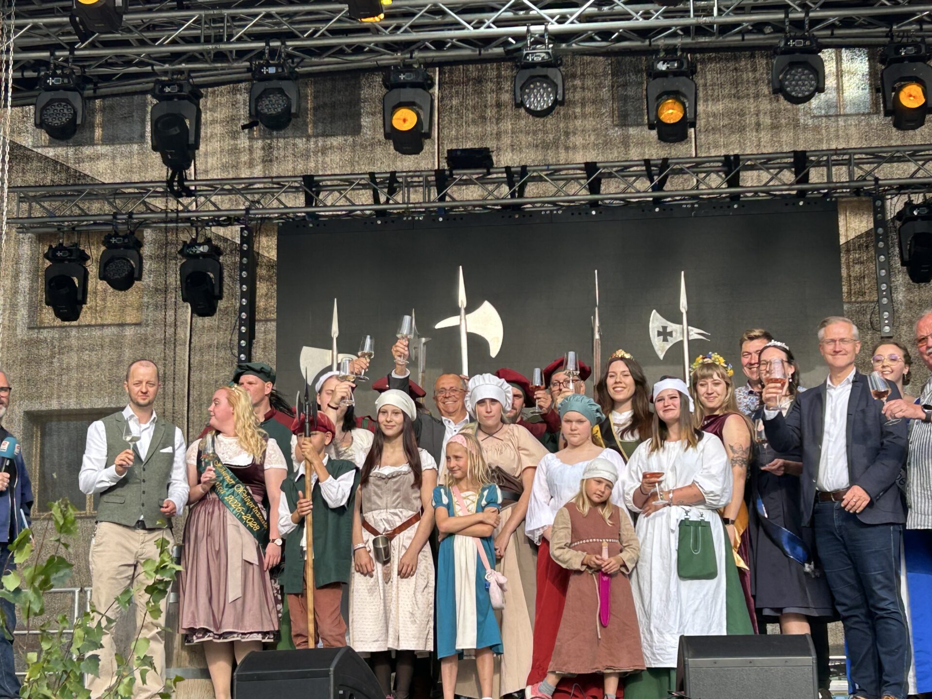 Eine Gruppe von Menschen in historischen Gewändern steht auf einer Bühne