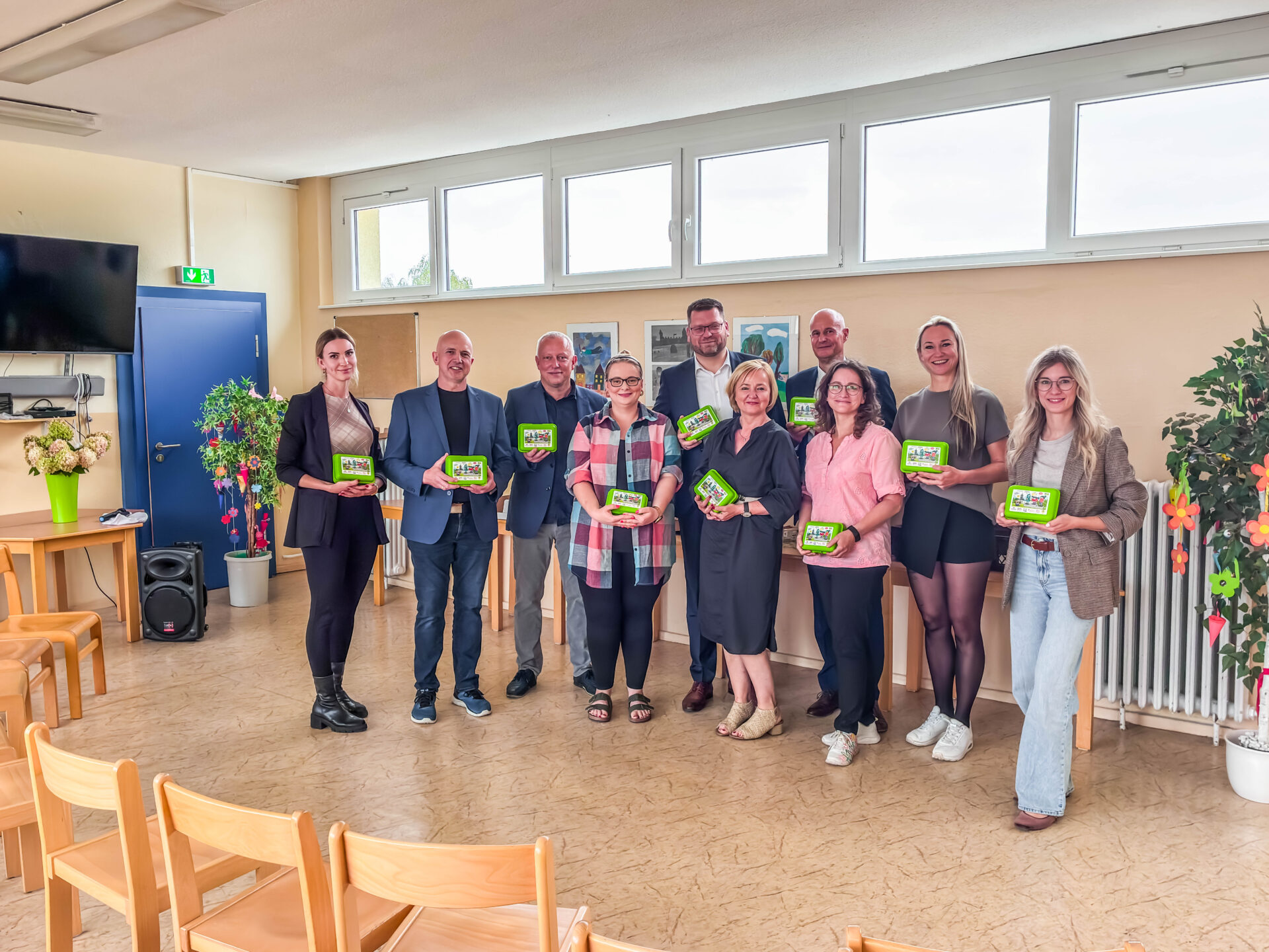 Eine Gruppe von Menschen steht in einem Klassenraum und präsentiert die Bio-Brotbox.