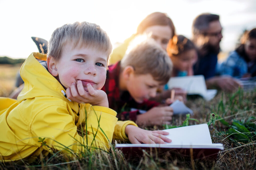Kinder lesen auf der Wiese
