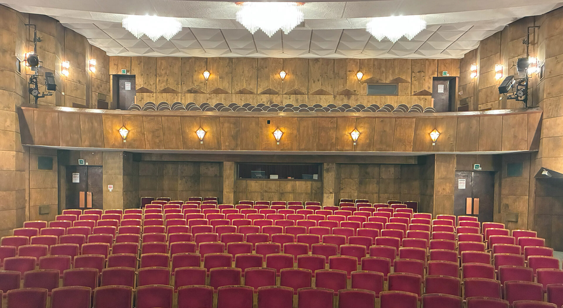 Asicht des Saals im Phönix Theater Wittenberg mit Ansicht von der Bühne nach hinten in den Saal. Rote Theaterstuhlreihen sind zu sehen.