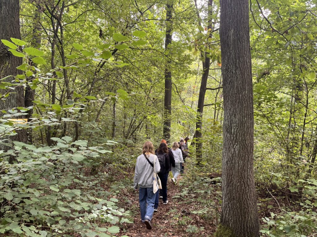 Personen auf dem Lehrpfad im Wald