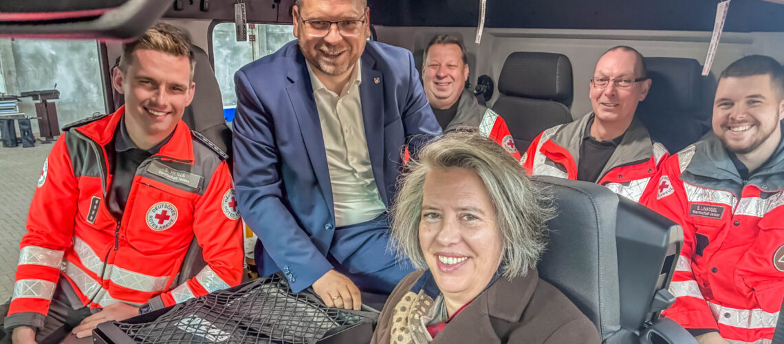 Landrat Christian Tylsch, Tamara Zieschang und Helfer des DRK Jessen machen gemeinsam Probesitzen im neuen Gerätewagen Betreuung.
