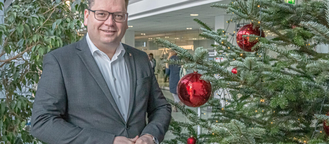 Landrat Christian Tylsch steht neben dem Weihnachtsbaum
