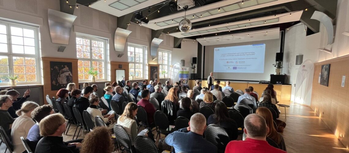 Saal gefüllt mit Menschen auf Stühlen bei Veranstaltung im Piesteritzer Hof