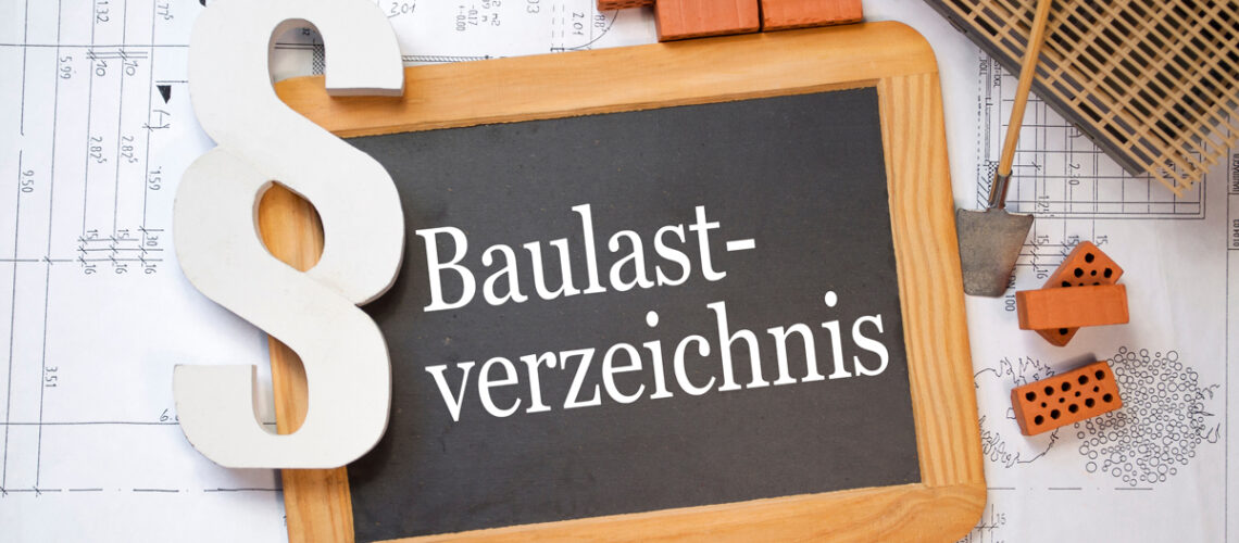 Auf einen Baulplan liegt ein Schild mit der Aufschrift Baulastverzeichnis. Daneben liegen Ziegelsteine, eine Schaufel und das Symbol einen Paragraphen.