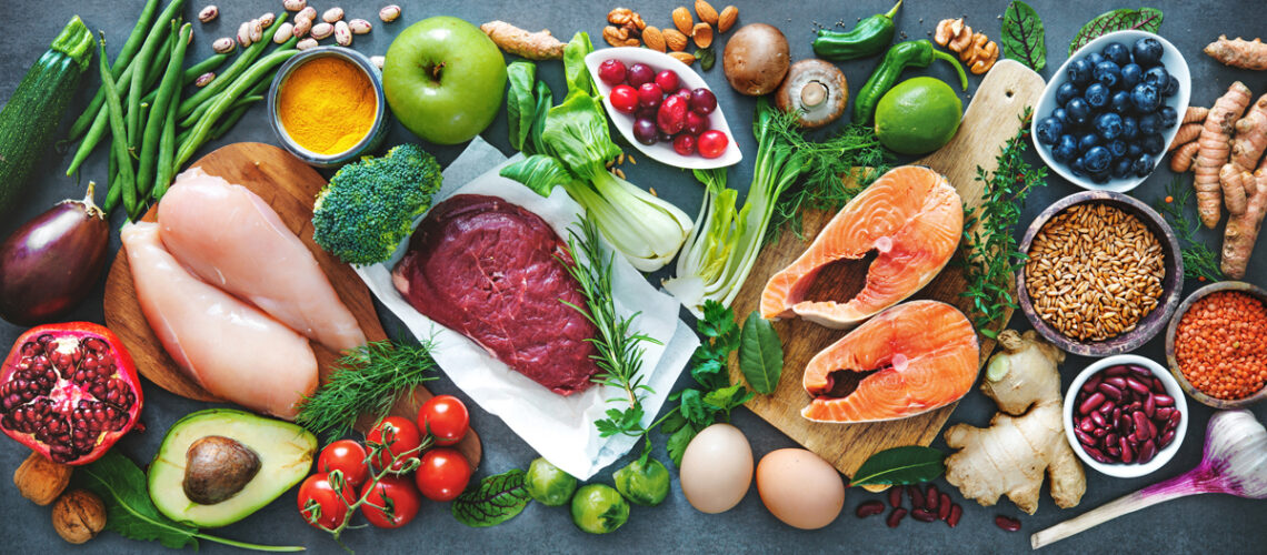 verschiedene Lebensmittel liegen auf einen Tich oder Arbeitsplatte - Apfel, Eier, Limette, Heidelbeeren, Pilze, Nüsee, Ingwer, Fisch