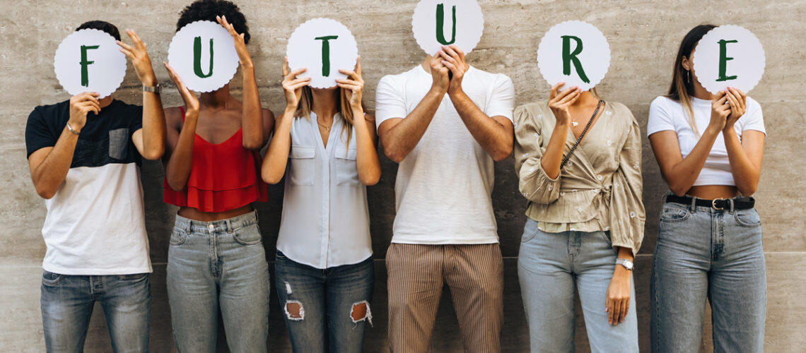 Junge Menschen verstecken ihre Gesichter hinter dem Wort „Zukunft“