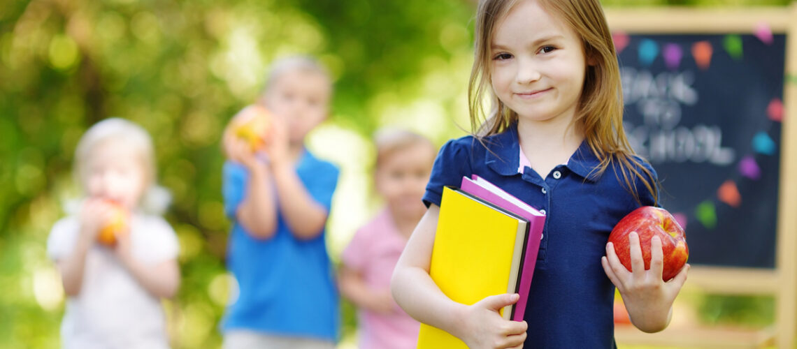 Aufgeregtes kleines Schulmädchen, das zurück zur Schule geht