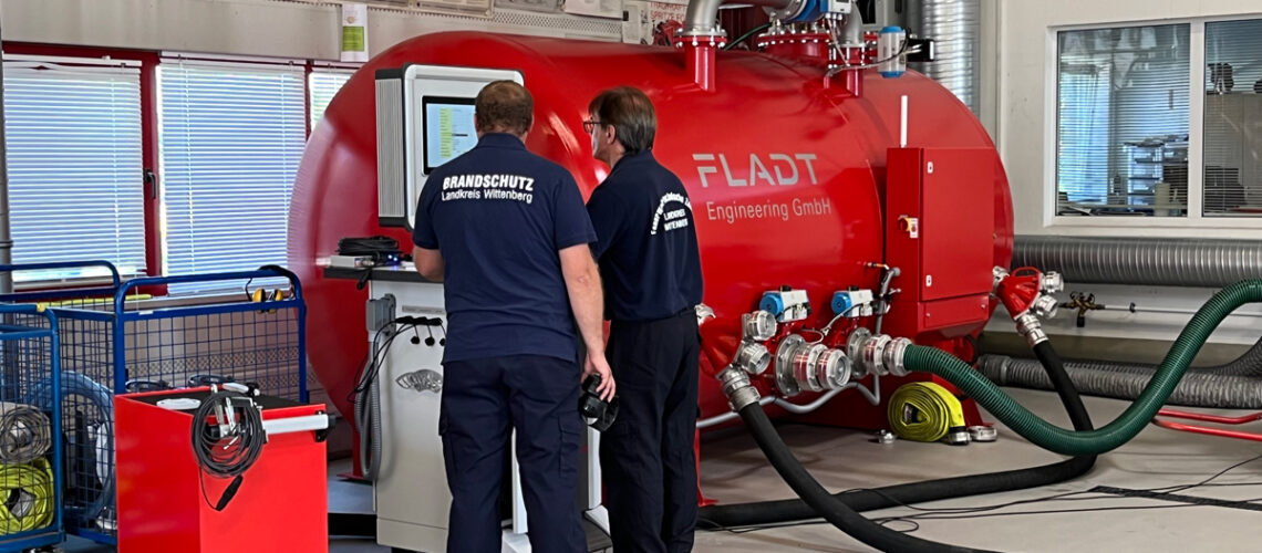 Brandschutzmitarbeiter stehen an der Pumpe