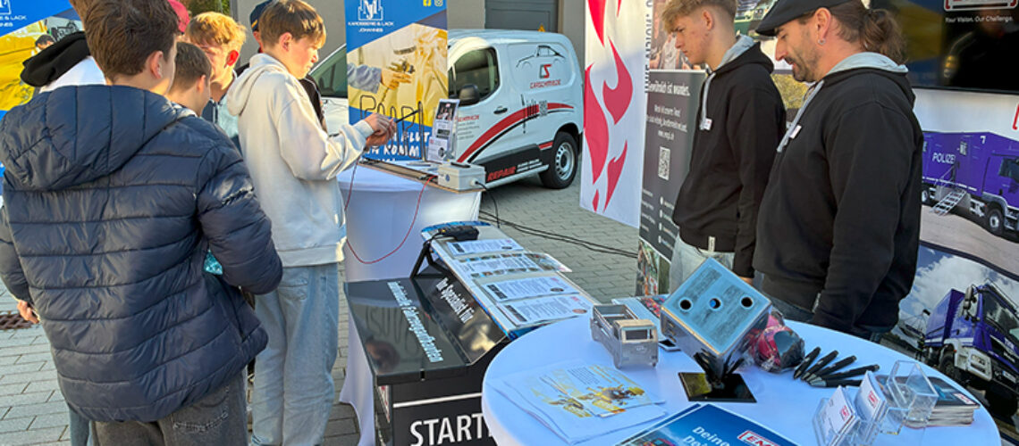 Schüler stehen an einem Infostand.