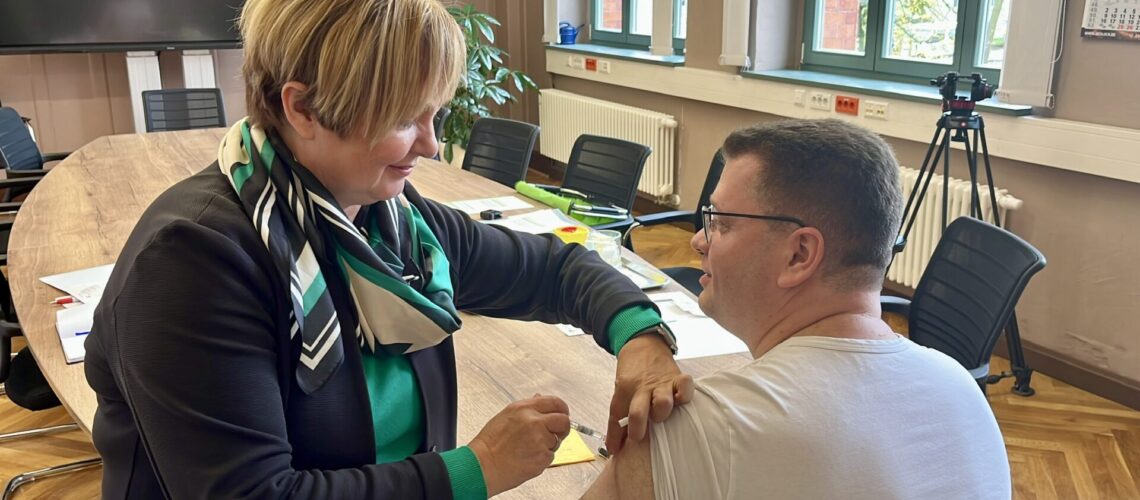 Landrat Christian Tylsch wird von Susanne Göbel aus dem Gesundheitsamt gegen Grippe geimpft.