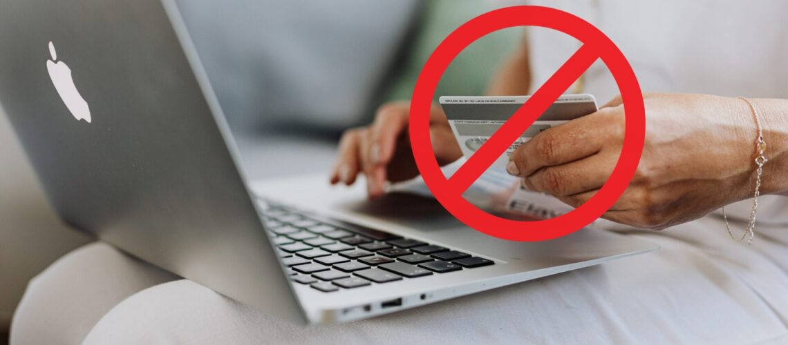 Person bezahlt online mit der Kreditkarte - darüber ist ein Warnzeichen